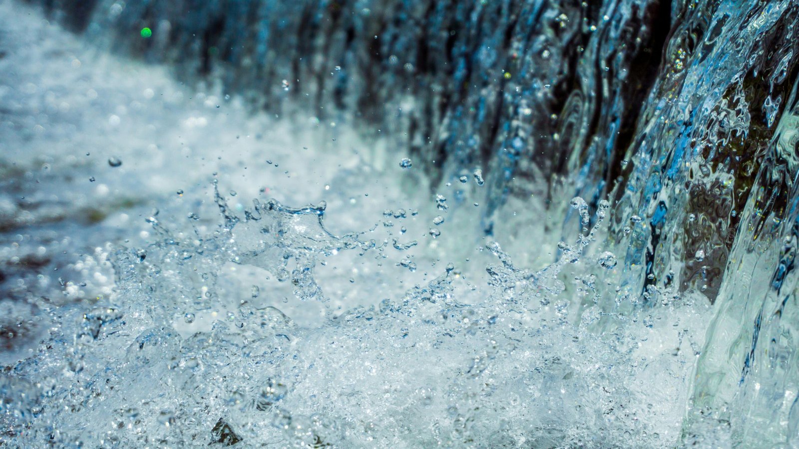 Close-up of water splashing with droplets in motion, showcasing nature's dynamic beauty.
